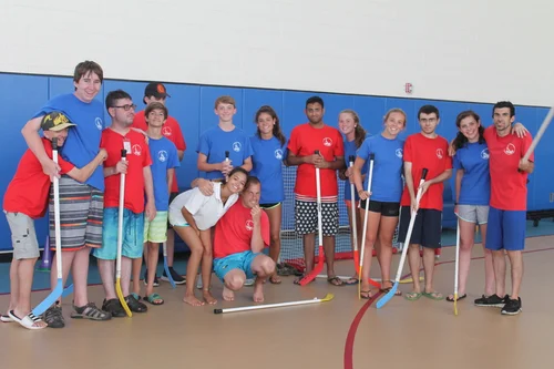 A floor hockey team posing together with their sticks