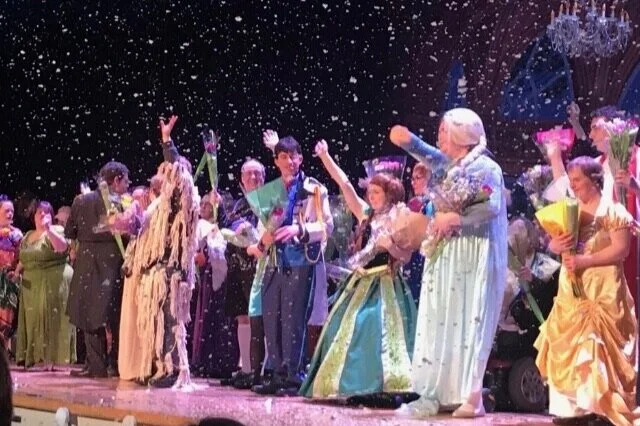 Campers performing on stage in costume during a drama production