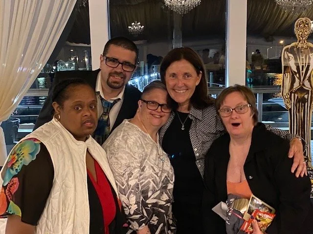 Campers and staff smiling together at an evening event